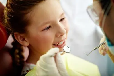 pediatric patient getting a dental checkup after getting dental crowns