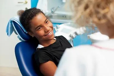 young patient smiling in the dentist's chair while visiting The Kid's Place in Boerne, TX