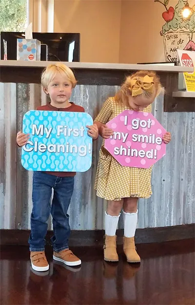 young patients holding up fun signs at The Kid's Place in Boerne, TX